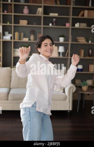 Vue verticale, jeune femme dansant en écoutant de la musique à l'aide d'écouteurs Banque D'Images