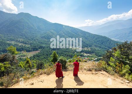 Bhoutan, 26 octobre 2021 : deux moines bouddhistes regardent le paysage montagneux du Bhoutan près du monastère de Tiger Nest. Le chemin vers le haut est un spiritua Banque D'Images