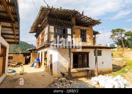 Paro, Bhoutan - 24 octobre 2021 : maison de ferme décrépite. Architecture bhoutanaise traditionnelle. Toit en bois protégé par du fer ondulé pour prévenir Banque D'Images