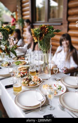 Repas en famille sur la terrasse d'été. Mains tout en toaster avec des verres de vin. Des gens heureux à la fête sur la terrasse Banque D'Images