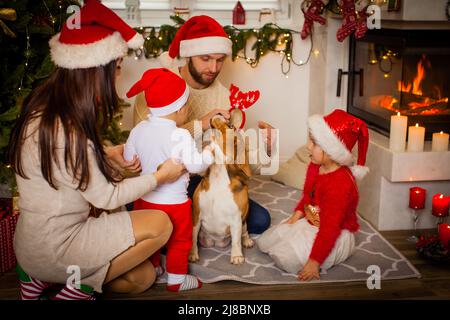 Une famille heureuse avec un chien beagle attend Noël Banque D'Images