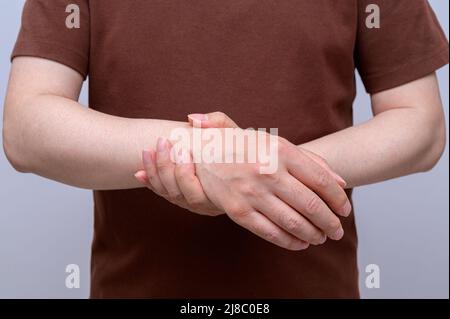 Un homme s'est enroulé autour de son poignet en raison de douleurs au poignet. Causes de la polyarthrite rhumatoïde, syndrome du canal carpien, goutte. Concept de soins de santé et de médecine. Banque D'Images