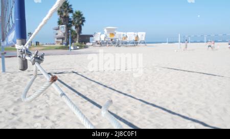 Les personnes jouant au volley-ball sur la plage, refuge de sauveteurs sur la côte californienne, États-Unis. Palmiers et terrain de sport en plein air, terrain de jeux ou terrain sur une rive sablonneuse. Jeu de loisirs avec filet et balle sur la plage de Mission Banque D'Images