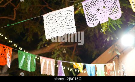 Guirlande papel picado, drapeaux perforés en papier. Décor ethnique mexicain coloré pour les vacances, le carnaval, la fête ou la fête. Festival de décoration de rue, Cinco de Mayo, Day of Dead ou Dia de Muertos. Banque D'Images