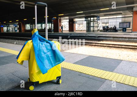 valise jaune avec drapeau ukrainien à la gare d'immigration réfugié Banque D'Images