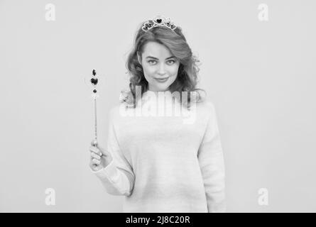 femme souriante à tête rouge dans la couronne de reine avec baguette magique, wish Banque D'Images