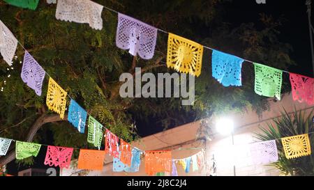 Guirlande papel picado, drapeaux perforés en papier. Décor ethnique mexicain coloré pour les vacances, le carnaval, la fête ou la fête. Festival de décoration de rue, Cinco de Mayo, Day of Dead ou Dia de Muertos. Banque D'Images