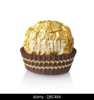 Bonbons au chocolat enveloppés d'une feuille d'aluminium dorée dans une tasse en papier isolée sur du blanc Banque D'Images