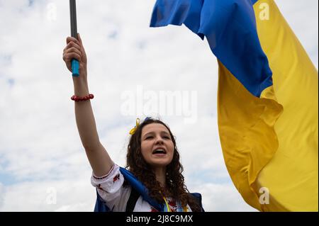 14.05.2022, Berlin, Allemagne, Europe - une jeune femme ukrainienne fait la vague d'un drapeau national bleu et jaune et proteste lors d'une manifestation pacifique. Banque D'Images