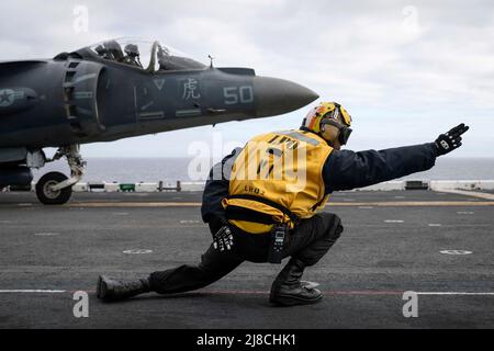 U.S. Navy Aviation Boatswains Mate 1st Class Reymond Rallos signale à un Marine corps AV-8B Harrier attaché à l'unité expéditionnaire maritime 22nd, de lancer à partir du pont de vol du navire d'assaut amphibie de classe Wasp USS Kearsarge, le 20 avril 2022 sur l'océan Atlantique. Banque D'Images