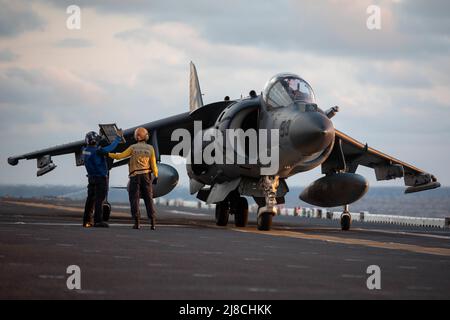 L'équipage du pont de vol de la Marine américaine doit tenir des instructions à un avion de chasse AV-8B Harrier du corps des Marines attaché au Tigers de l'escadron d'attaque maritime 542, avant le lancement sur le pont de vol du navire d'assaut amphibie de classe Wasp USS Kearsarge, le 23 septembre 2021 opérant sur l'océan Atlantique. Banque D'Images