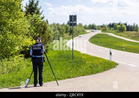 15 mai 2022, Bade-Wurtemberg, Pforzheim: Un policier mesure la vitesse d'une voiture qui s'approche. Le siège de la police de Pforzheim effectue aujourd'hui un contrôle à grande échelle de la moto sur le B500 dans le district de Freudenstadt. Photo: Philipp von Ditfurth/dpa Banque D'Images