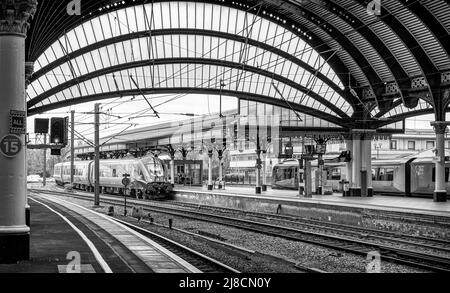 Les trains se tiennent à côté d'une voûte historique vue de dessous une arche. Les colonnes sont au premier plan. Banque D'Images