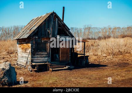 Ancienne maison en bois en ruine se trouve seule dans la steppe. Les logements abandonnés ont été délabrés. Terrain désertique. Banque D'Images