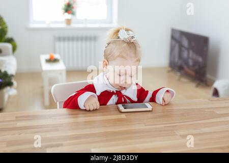 Enfant fille vêtue de la robe de noël avec implants cochléaires s'amuser à la maison - aide auditive et technologies innovantes pour le traitement de la surdité Banque D'Images