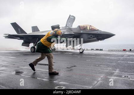 Le chef de l'aviation de la Marine américaine, le Mate Akiel Meyers, signale un avion de chasse F-35B Lightning II du corps maritime, attaché aux dragons du Marine Medium Tiltrotor Squadron 265, pour lancer à partir du pont de vol du navire d'assaut amphibie de classe américaine USS America, le 17 janvier 2022 opérant sur la mer de Chine orientale. Banque D'Images