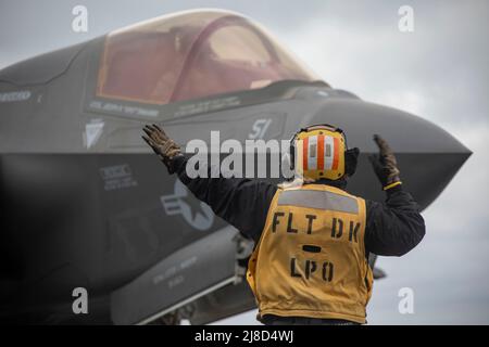 U.S. Navy Aviation Boatswains Mate 1st Class Jenna Leggett dirige un avion de chasse F-35B Lightning II du corps des Marines des États-Unis, attaché aux Nightriders de l'escadron de Tiltrotor intermédiaire marin 164, après l'atterrissage sur le pont de vol du navire d'assaut amphibie de classe Wasp USS Makin Island pendant l'opération Northern Edge 2021, Le 7 mai 2021 en exploitation dans le golfe de l'Alaska. Banque D'Images