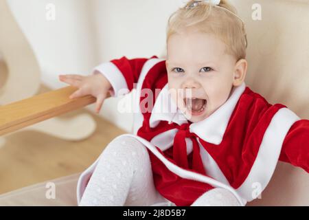 Enfant fille vêtue de la robe de noël avec implants cochléaires s'amuser à la maison - aide auditive et technologies innovantes pour le traitement de la surdité Banque D'Images