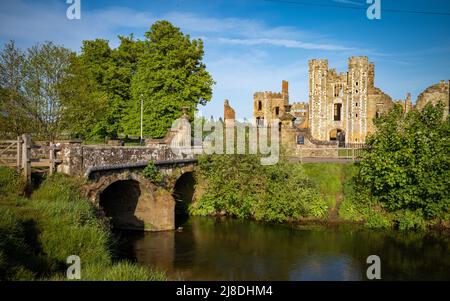 Un ancien pont en pierre au-dessus de la rivière Rother menant à l'entrée des ruines de Cowdray House à Midhurst, West Sussex, Angleterre, Royaume-Uni. Banque D'Images