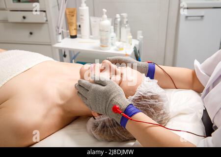 Une femme subit une procédure de rajeunissement facial dans une clinique de cosmétologie. Obtenir l'hydromicrodermabrasion faciale peeling. Traitement cosmétique Banque D'Images