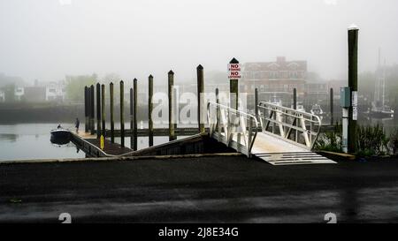 NORWALK, CT, USA - 15 MAI 2022 : magnifique brouillard matinal près du centre-ville avec marée basse dans la rivière Norwalk et les gens dans la zone d'amarrage Banque D'Images