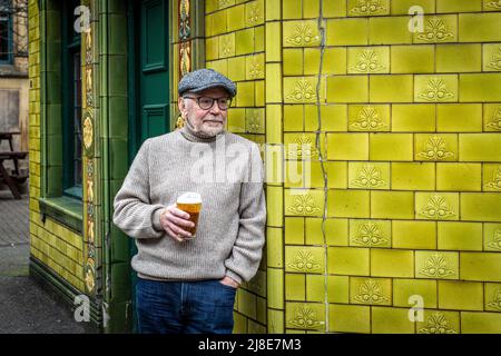 Des hommes se tiennent devant un pub pour prendre un verre au pub traditionnel anglais Peveril of the Peak, situé sur Great Bridgewater Street, Manchester, Royaume-Uni Banque D'Images