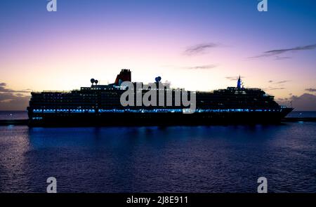 Bridgetown, Barbade - 25 mars 2022 : le soleil se couche derrière le paquebot de croisière Cunard Queen Victoria, à Bridgetown Dock Banque D'Images