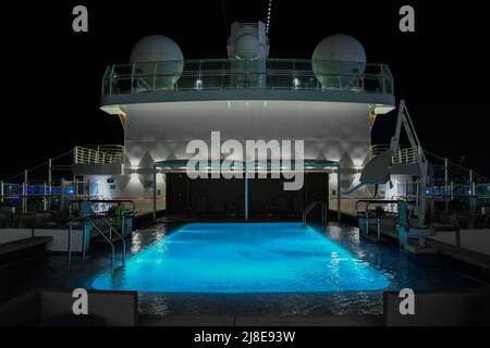 Bridgetown, Barbade - 25 mars 2022 : un photographe de nuit de la zone de la piscine de la terrasse supérieure à bord du paquebot de croisière P and O Britannia dans le quai de Bridgetown Banque D'Images