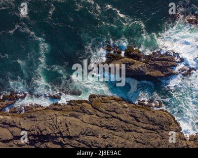 Tir à partir d'un drone. Magnifique paysage marin. Lamer des pierres rugueuses près de la rive de l'océan. Eau de mer avec vagues mousseuse blanches. Beauté de la nature, paysage majestueux Banque D'Images