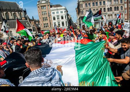 Des manifestants palestiniens sont vus en possession d'un grand drapeau palestinien au centre de la place du Dam lors d'un rassemblement à l'occasion du 74th anniversaire de la Journée Nakba à Amsterdam. Des manifestants palestiniens se sont rassemblés pour un rassemblement sur la place du Dam à Amsterdam à l'occasion du 74th anniversaire de la Journée Nakba et pour condamner le meurtre de la journaliste israélo-palestinienne Shireen Abu Akleh par les forces israéliennes. Le mot « Nakba » signifie « catastrophe » en arabe et fait référence au nettoyage ethnique systématique des deux tiers de la population palestinienne à l'époque par des paramilitaires sionistes entre 1947-1949 et le quasi-tota Banque D'Images