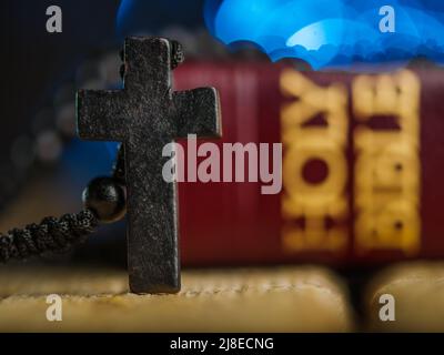Croix catholique antique, livre biblique Saint sur une table en bois sur fond bleu. Gros plan. Il n'y a aucune personne dans la photo. Religion, Christiani Banque D'Images
