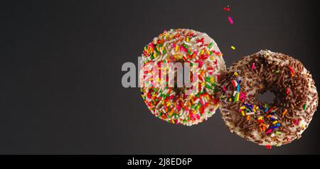 Deux beignets de couleur surgelé sur fond gris clair. Publicité, bannière, invitation pour anniversaire, vacances. Il n'y a pas de personnes dans le ph Banque D'Images