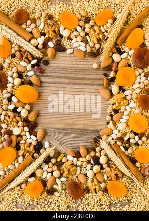 Ingrédients du dessert ahura ; noix, noisettes, blé, haricots, abricot, raisin et pois chiches sur une surface en bois conçue comme un cadre avec espace de copie Banque D'Images