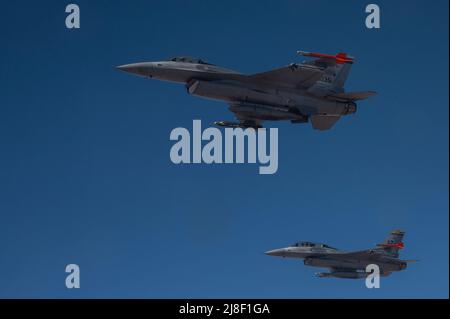 La Garde nationale aérienne de l'Arizona F-16 combat les faucons avec la 162nd Wing volent en formation lors d'un ravitaillement en vol à partir d'un KC-135 Stratotanker de la 161st Air Fighting Wing lors d'une sortie locale le 14 mai 2022 au-dessus de l'Arizona. (É.-U. Photo de la garde de la nation aérienne par le sergent d'état-major. James A. Richardson Jr.) Banque D'Images