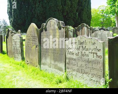 Une lignée de pierres tombales datant de 16th ans dans le cimetière de l'église St Hildas classée en Grade 2 dans le Yorkshire du Nord de l'Angleterre Banque D'Images