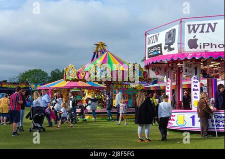 Les gens qui apprécient les divertissements lors de la foire annuelle de mai dans le parc par une journée ensoleillée Banque D'Images