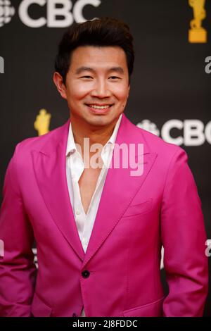 L'hôte Simu Liu porte un costume fuchsia audacieux sur le tapis rouge aux Juno Awards 2022 à Toronto, AU CANADA Banque D'Images