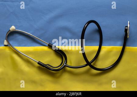 Le stéthoscope se trouve sur le drapeau national de l'Ukraine jaune-bleu, la loi martiale en Ukraine, les soins médicaux dans la guerre. Guerre en Ukraine 2022 Banque D'Images