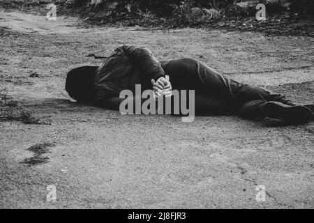 Une femme ukrainienne morte se trouve dans la rue avec ses mains attachées avec une corde blanche et a été tuée dans le dos en Ukraine, une manifestation de mort dans la ville de Banque D'Images