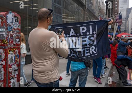 New York, États-Unis. 15th mai 2022. Un homme photographie un signe un signe qui dit 'A.A.P.I. Vit Matter' avant le premier défilé culturel du patrimoine asiatique américain et insulaire de New York sur la Sixième Avenue à New York. Crédit : SOPA Images Limited/Alamy Live News Banque D'Images
