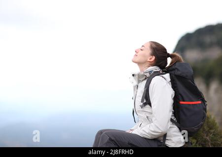 Profil d'un trekker respirant de l'air frais reposant dans la montagne Banque D'Images