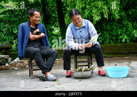 (220516) -- ZUNYI, 16 mai 2022 (Xinhua) -- Jian Qin (R), accompagné de son mari Zhao Youliang, pousse de bambou dans le canton de Zhongguan, comté de Zheng'an, province de Guizhou, sud-ouest de la Chine, 12 mai 2022. Vivant au fond des montagnes de Zunyi, dans la province de Guizhou, Zhao Youliang et Jian Qin sont un couple handicapé. Zhao, 50 ans, a perdu les mains en raison d'une amputation à un jeune âge, et Jian, 43 ans, a perdu la vue en raison du retard dans le traitement d'une maladie dans son enfance. Dans la vie quotidienne, Zhao aide sa femme à voir avec ses yeux, tandis que Jian aide son mari Banque D'Images