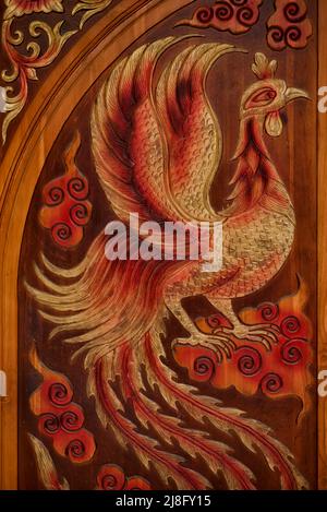 Porte en bois sculpté avec des figurines de poulet rôti et impressionnant plumage Thaïlande Asie du Sud-est Banque D'Images