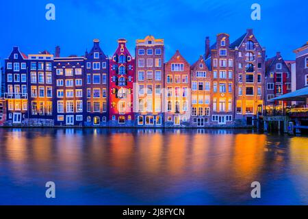 Amsterdam, pays-Bas. Maisons colorées au canal de Damrak. Banque D'Images