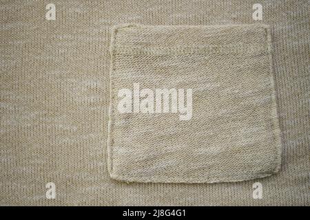 Chandail beige à motif confortable avec poche, fond crème tricoté Banque D'Images