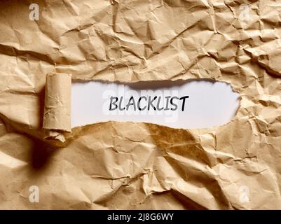 Le mot liste noire écrit sous un papier brun déchiré. Banque D'Images