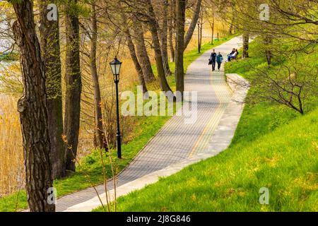 Elk, Pologne - 1 mai 2022 : promenade touristique le long du lac Jezioro Elckie rive boisée au printemps ville d'Elk de la région de Masuria en Pologne Banque D'Images