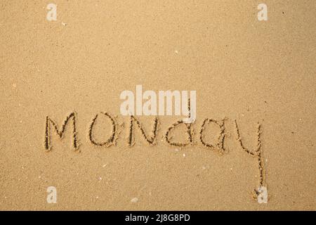 Lundi - tirage des jours de la semaine, manuscrit sur la plage de sable. Banque D'Images