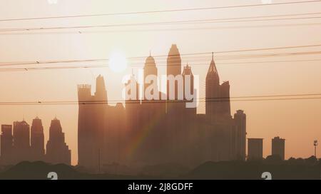 Paysage urbain incroyable. Arc-en-ciel sur le fond de la ville de Dubaï dans une lumière douce de coucher de soleil orange. Magnifique panorama urbain. La vie moderne des eau. Banque D'Images