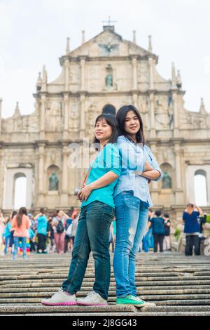 Les touristes asiatiques voyagent en face de l'architecture historique de l'église Saint-Paul à macao, en Chine Banque D'Images